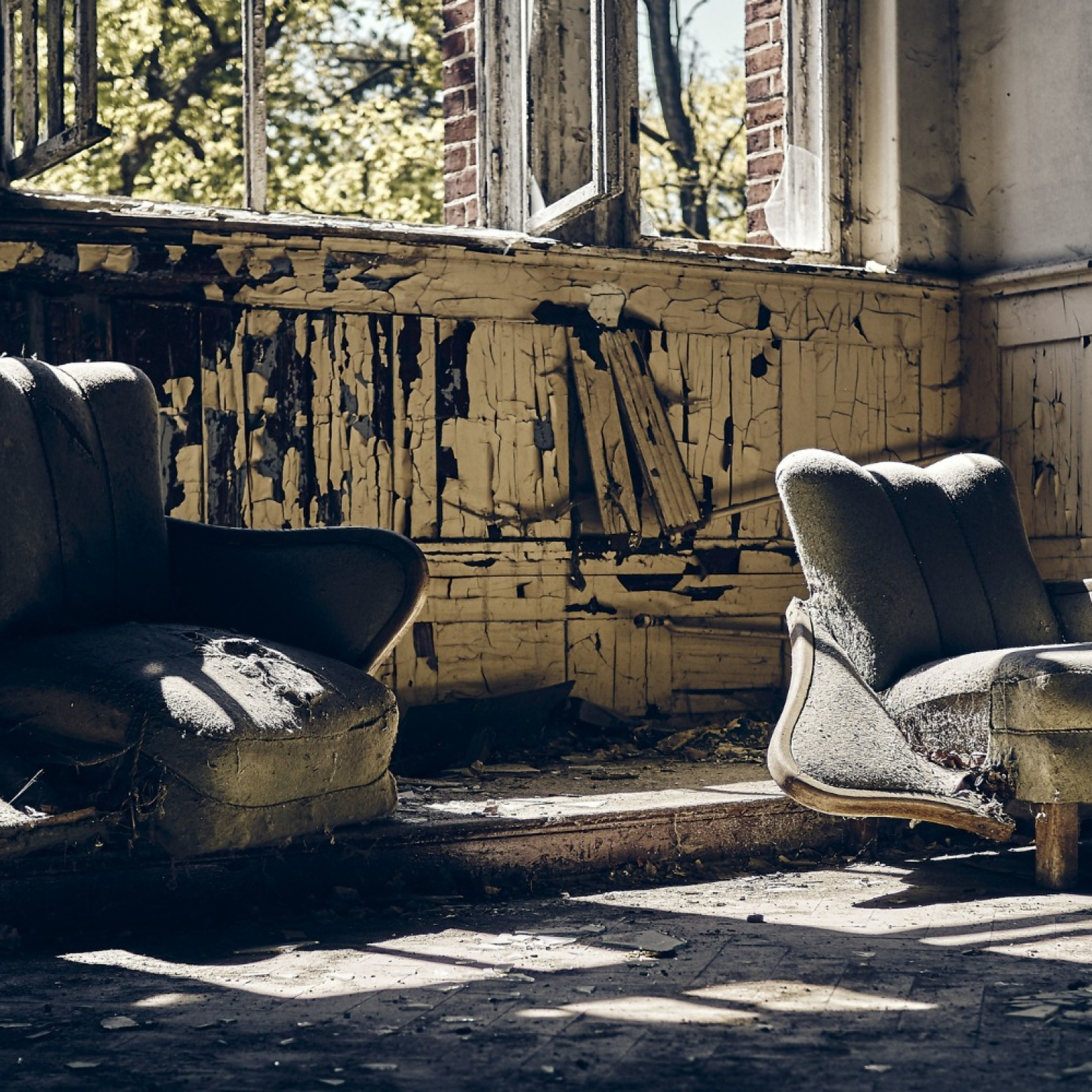 abandoned house with broken windows with two worn out sofas that can be use to repurpose old furniture