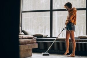 a sexy house wife vacuuming the living room while calling somebody on the mobile phone for a winter clean out checklist