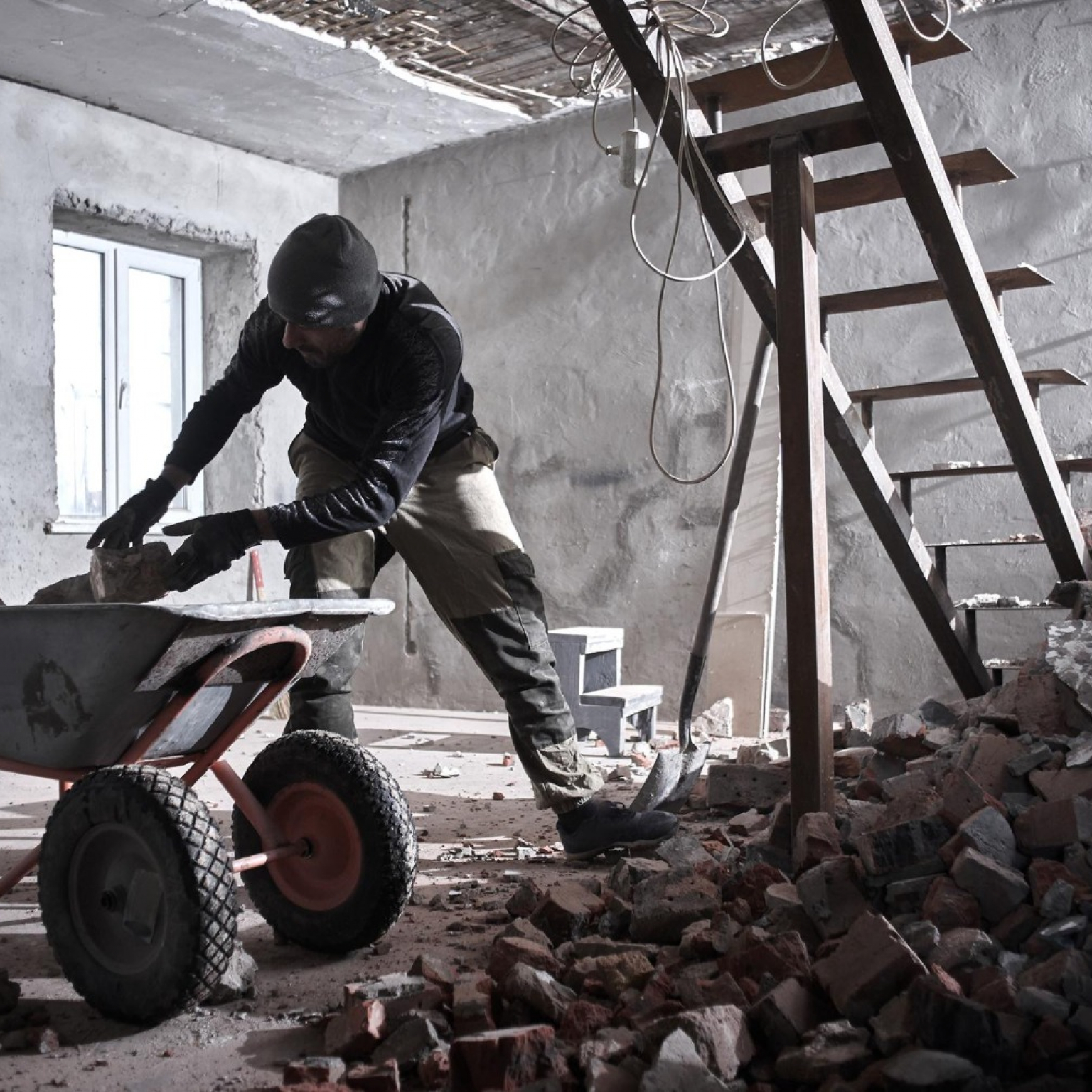 handyman-builds-house-breaks-down-walls-puts-bricks-construction-shovel-into-bricks-repair-process