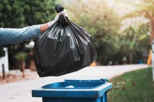 hand-holding-garbage-black-bag-putting-trash