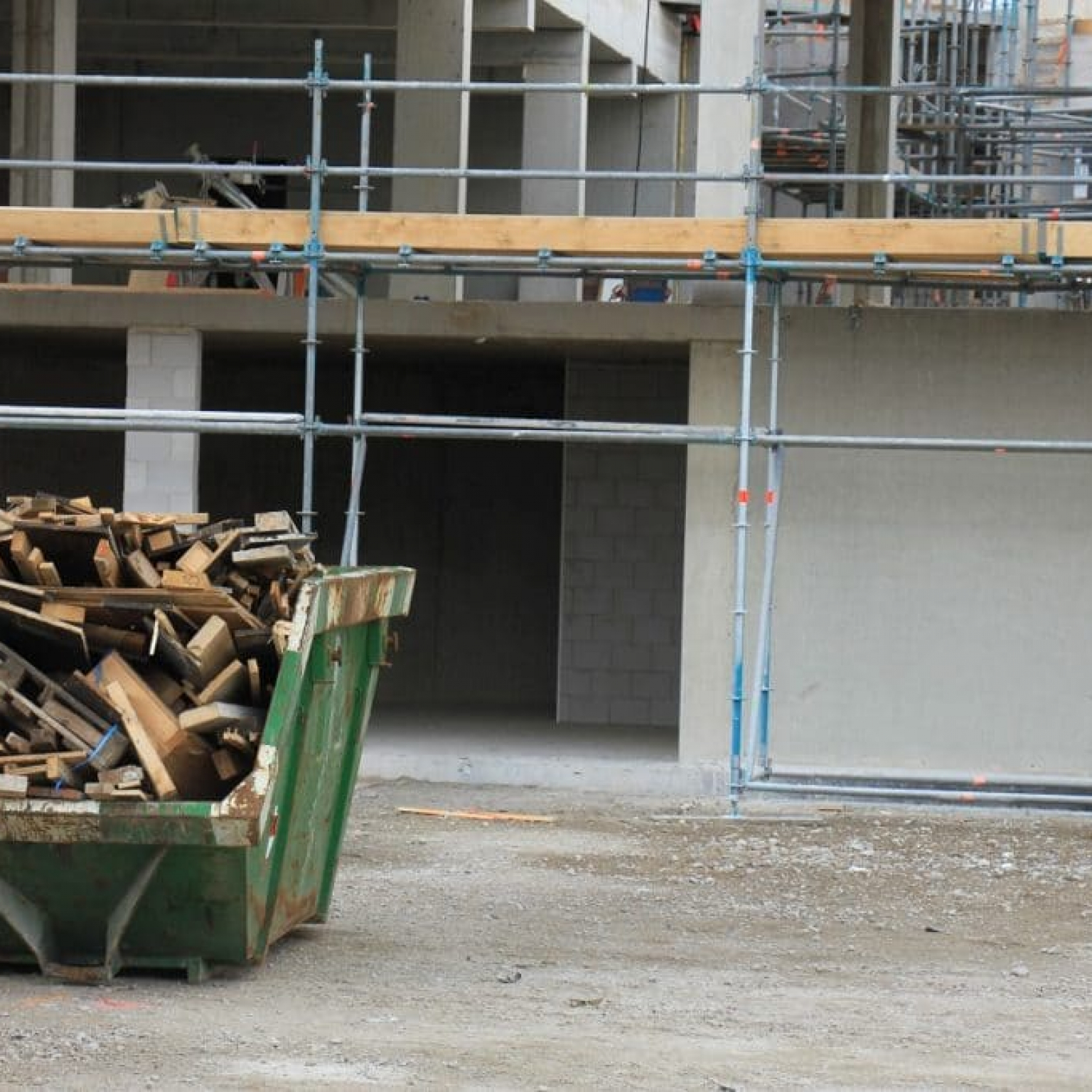 a dumpster bin loaded with wood debris near a construction site hire the right dumpster rental service
