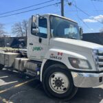 - benefits of hiring a professional junk removal service in canada. Junk It dumpster trailer truck on the street used for hiring a professional junk removal services