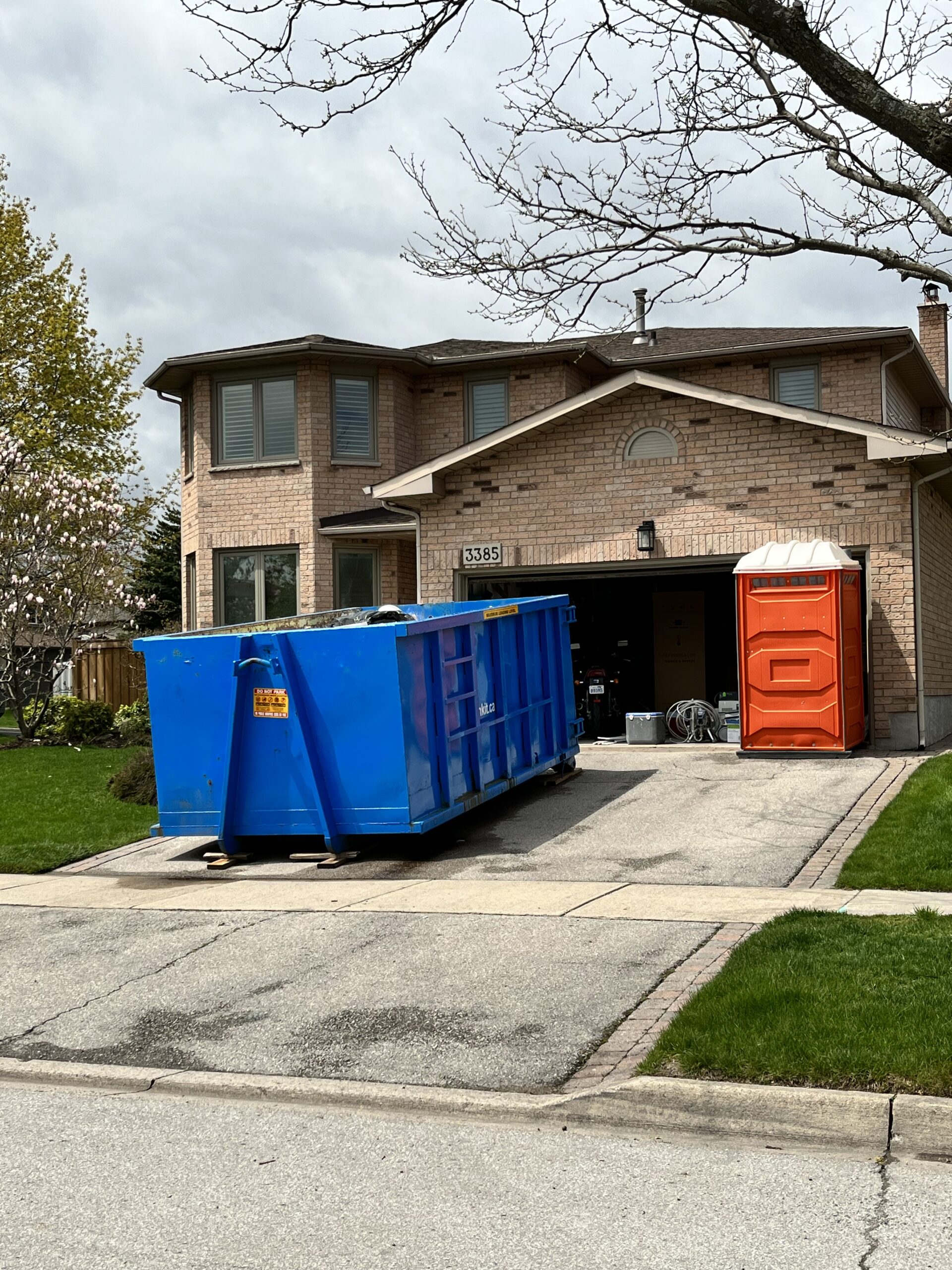 junk it blue garbage bin outside residential house