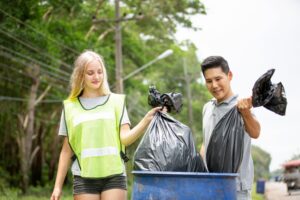 optimistic-two-volunteers-holding-garbage-bag-help-picking-up-trash-park-they-re-picking-up-garbage-putting-it-black-garbage-bag