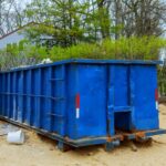 blue Junk It dumpster bin near the residential area for a dumpster near me