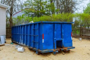 blue Junk It dumpster bin near the residential area for a dumpster near me