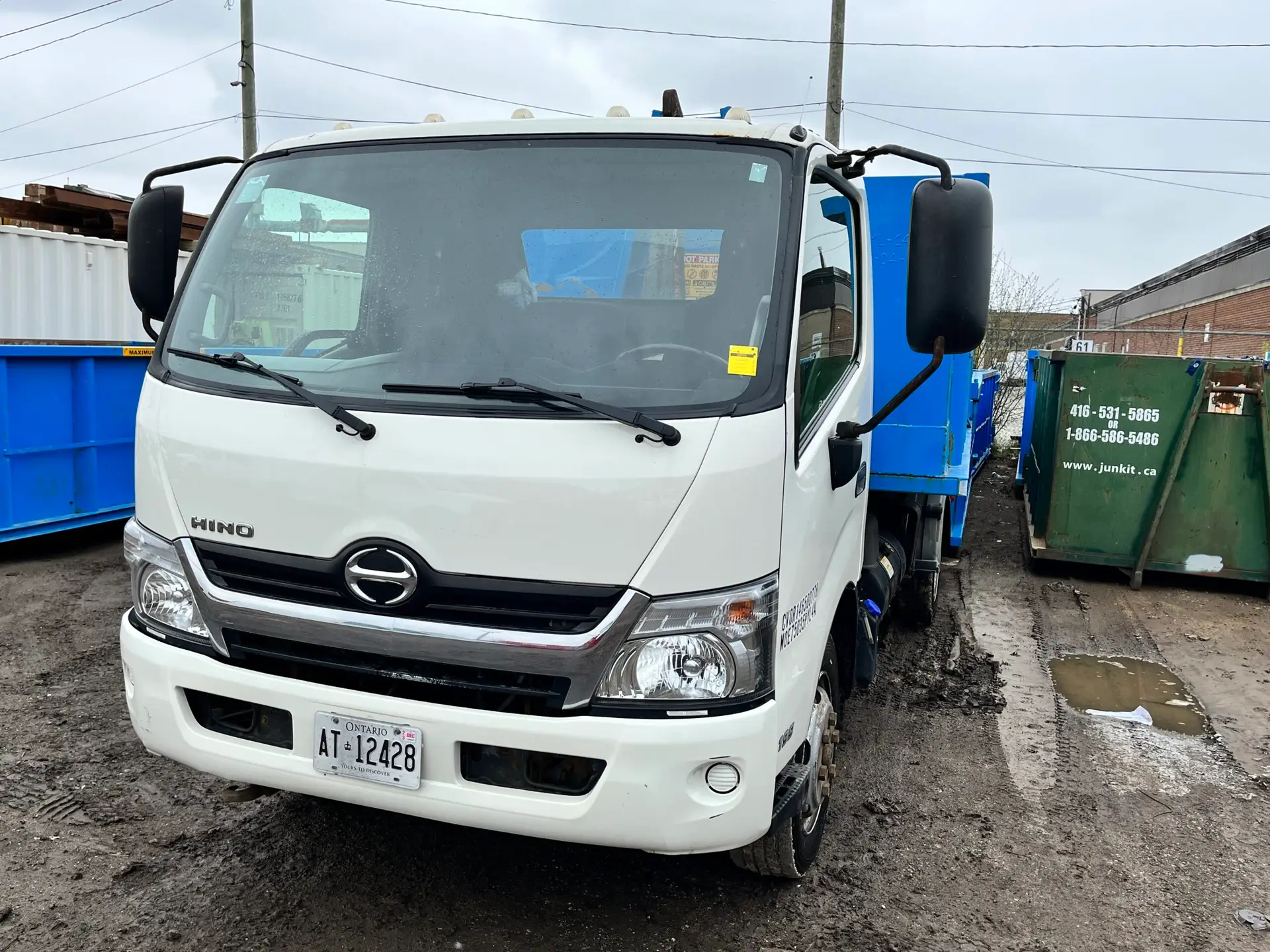 a Junk It white Hino truck, ready to deliver - reliable bin rental in Edmonton for all your waste disposal needs