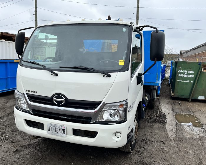 Junk It white Hino garbage bin delivery truck ready for garbage bin rental in Milton - offering convenient waste management solutions for your needs