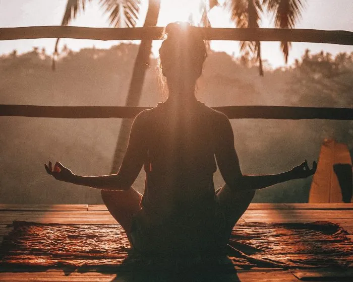 A woman doing yoga - staying mindful while considering a garbage bin rental in London, Ontario for a home decluttering project