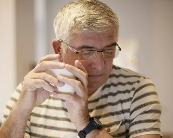 A man with glasses thinking while looking down - considering the best options for garbage bin rental in Richmond Hill to simplify his cleanup process