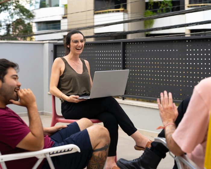 A woman with a laptop chatting with her friends - considering garbage bin rental in Richmond Hill for her home renovation