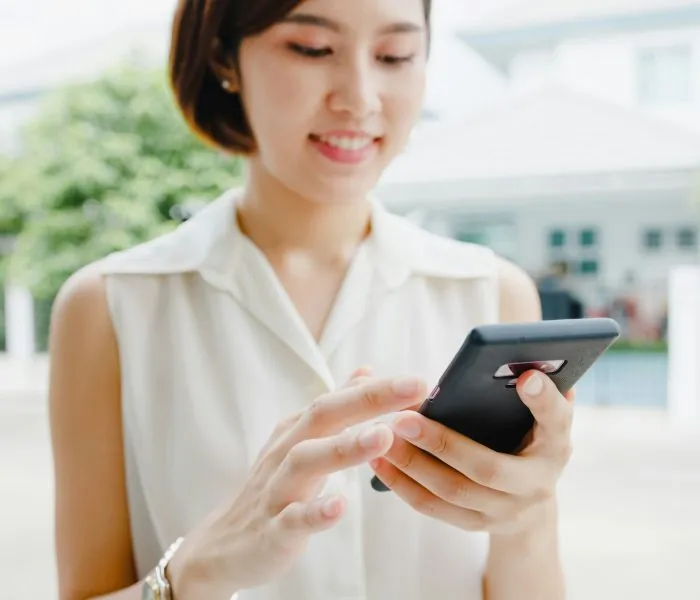 Woman looking at her black phone - considering convenient garbage bin rental in Scarborough for her next project