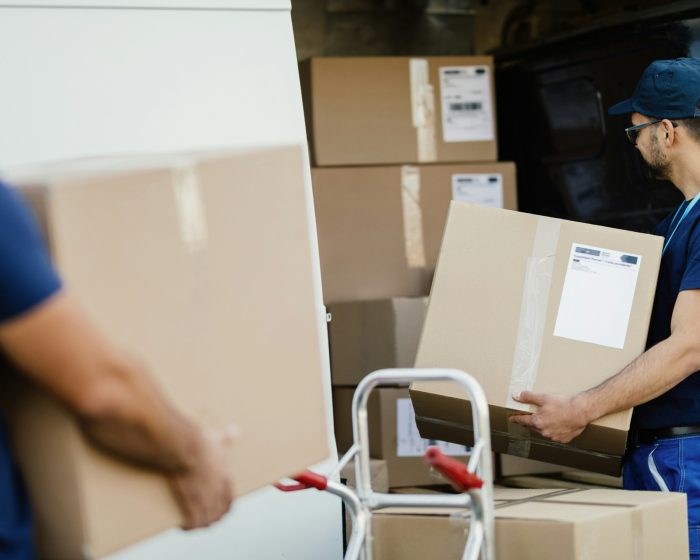 Junk It workers hauling boxes into a rental bin in Vaughan