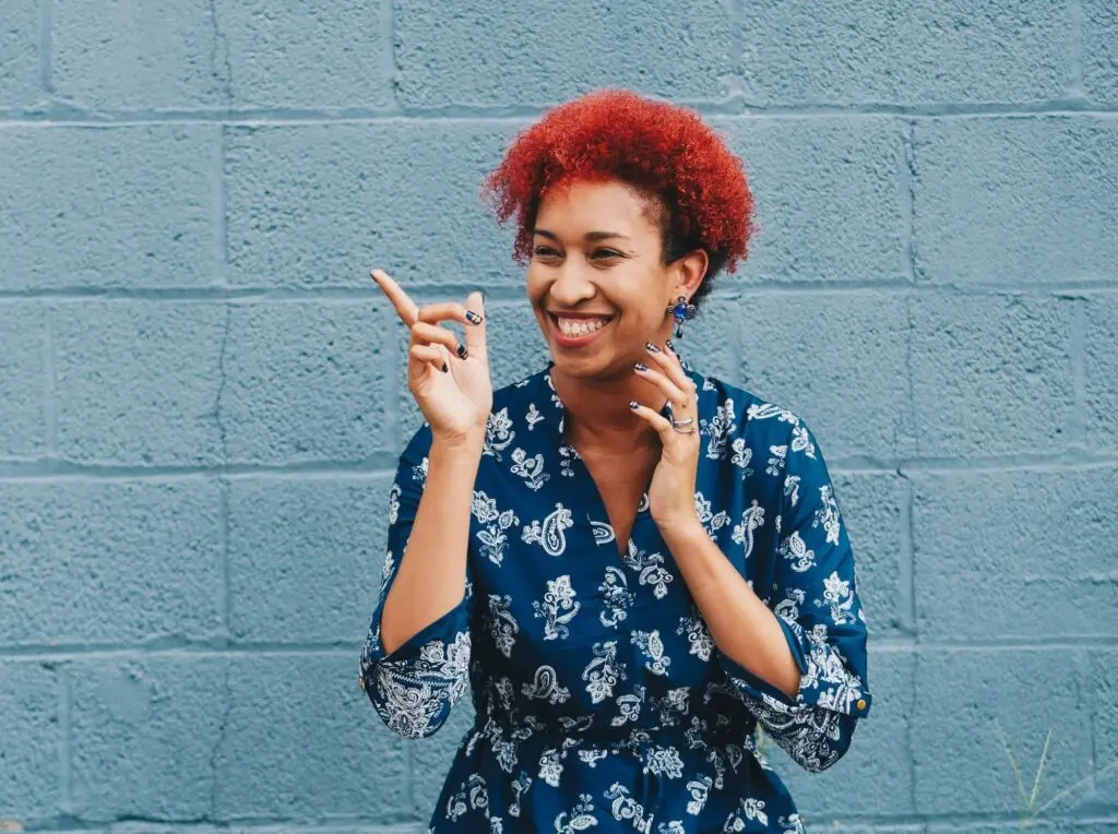 a woman smilling and pointing - be happy and satisfied just like junk it's clients who choosed junk it's residentail dumpster rental services in Canada - learn more about approved junk/trash for residential garbage bins