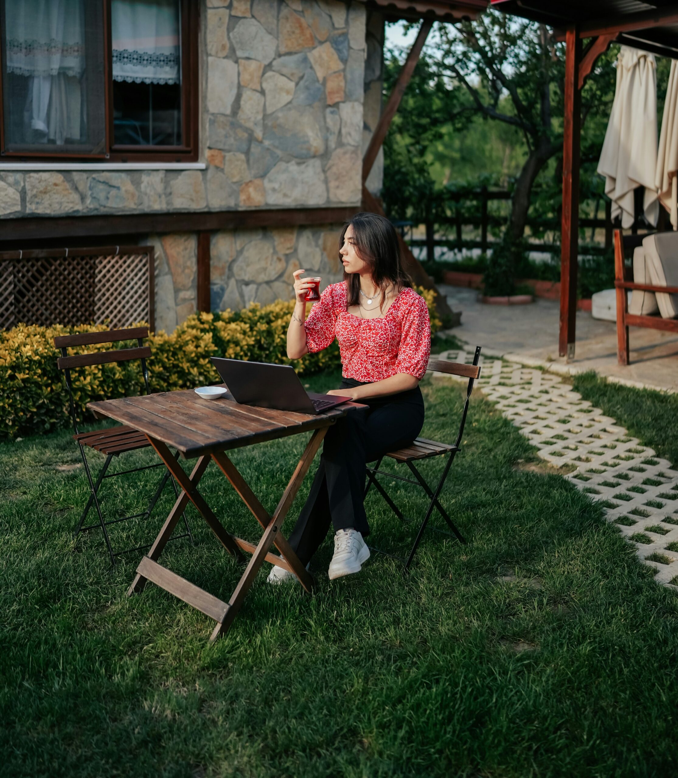 woman sitting in her yard, drinking cola and considering reliable bin rental services in Burlington