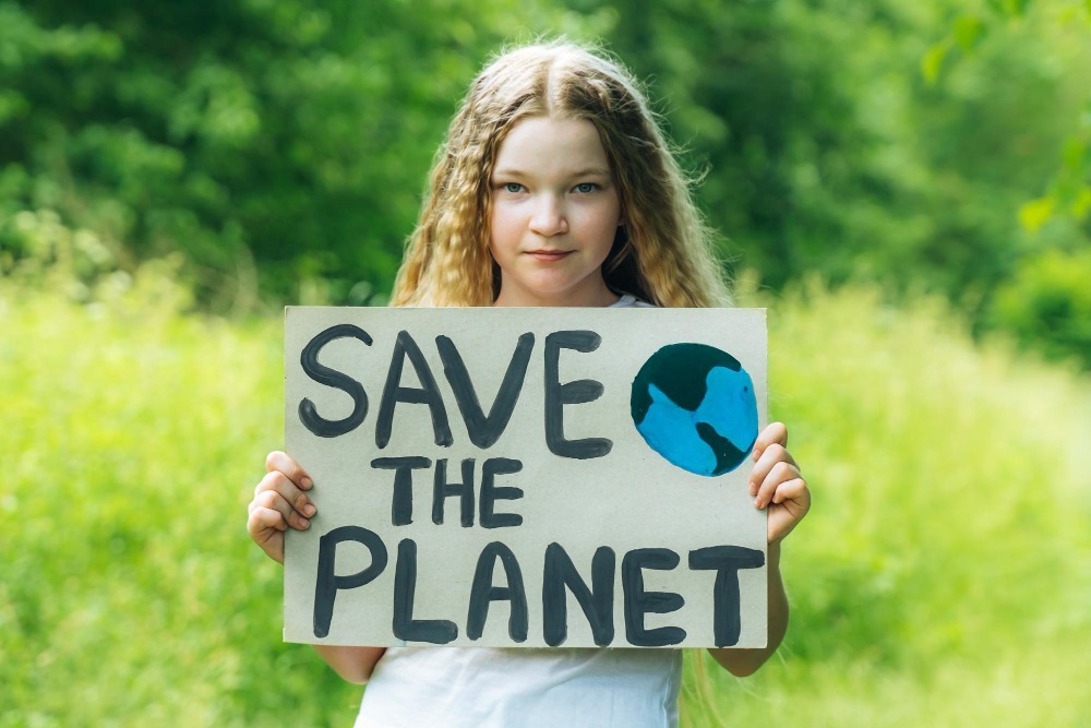 teen girl holding a save the earth signage - Junk It Dedicated to do Environment Friendly Operations