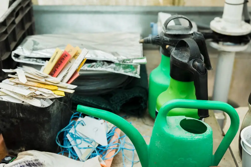 A pile of old watering cans and garden signs inside a cart, ready to be cleared out with the help of a reliable bin rental in Edmonton